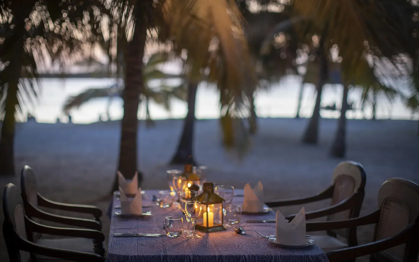 Beachfront dining table set for evening service, Manda Bay, Lamu Archipelago, Kenya