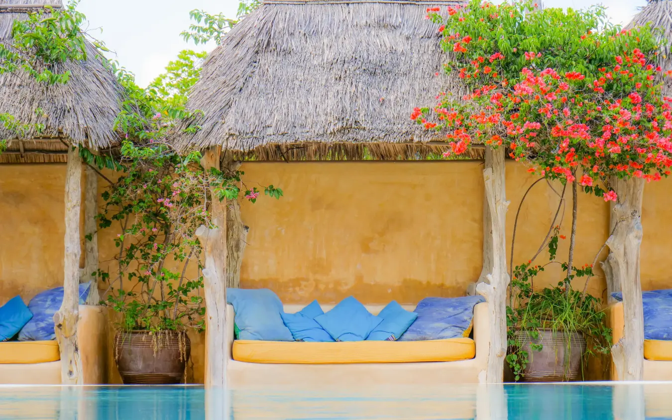Beachside cabana with blue cushions and flowering vines, Manda Bay, Lamu Archipelago, Kenya