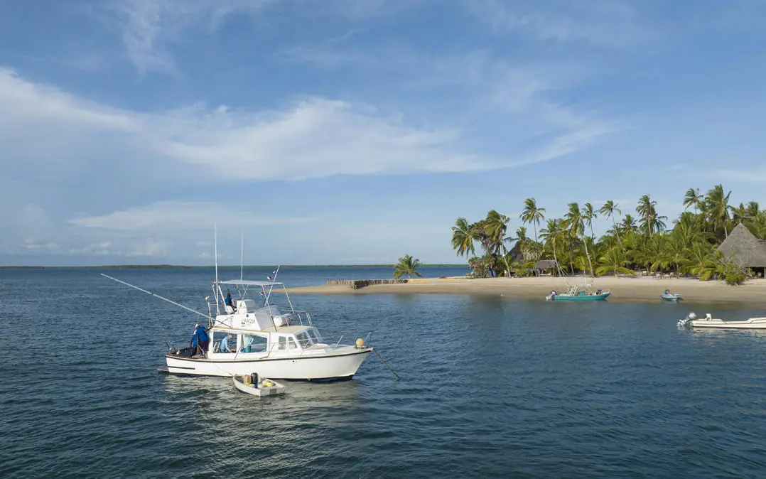 Fishing boat anchored in shallow tropical waters near beach, Manda Bay, Lamu Archipelago, Kenya