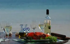 Wine and seafood dinner setup overlooking ocean horizon, Manda Bay, Lamu Archipelago, Kenya