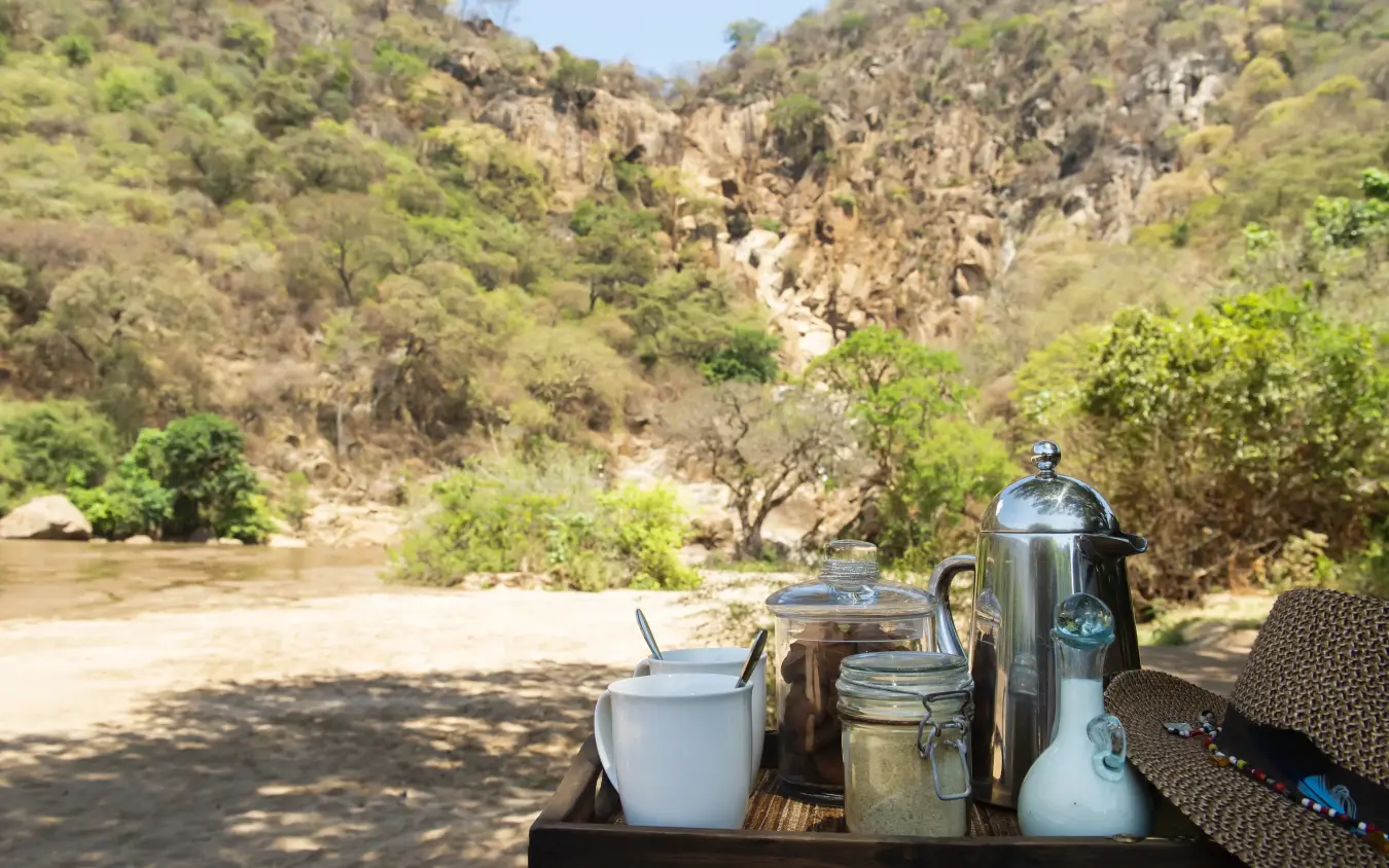 Morning tea service overlooking river and forested canyon, Manyara Green Camp, Lake Manyara, Tanzania