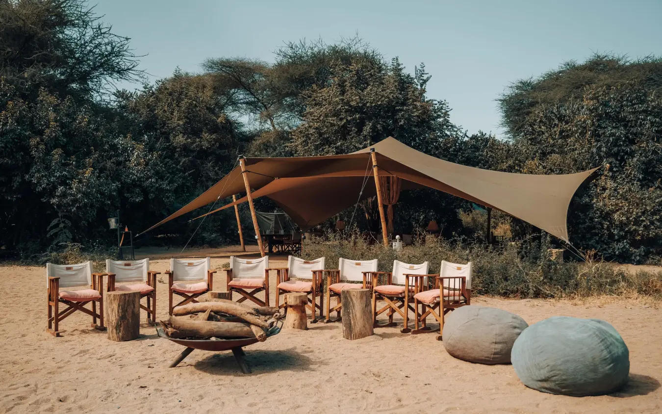 Sandy lounge area with canvas tent and fire pit, Manyara Green Camp, Lake Manyara, Tanzania