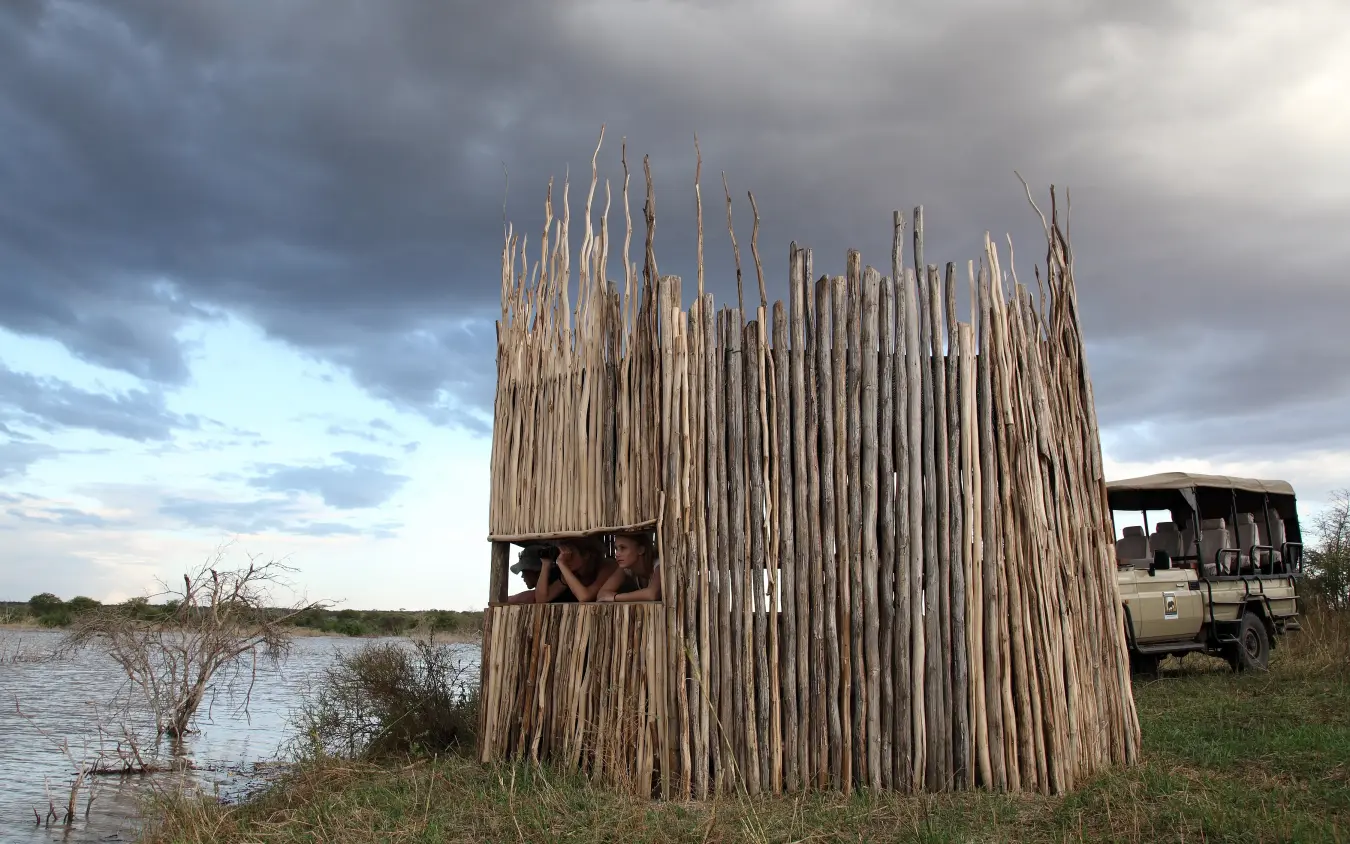 Observation tower with guests overlooking flooded wetland from safari vehicle, Manyara Ranch, Lake Manyara, Tanzania