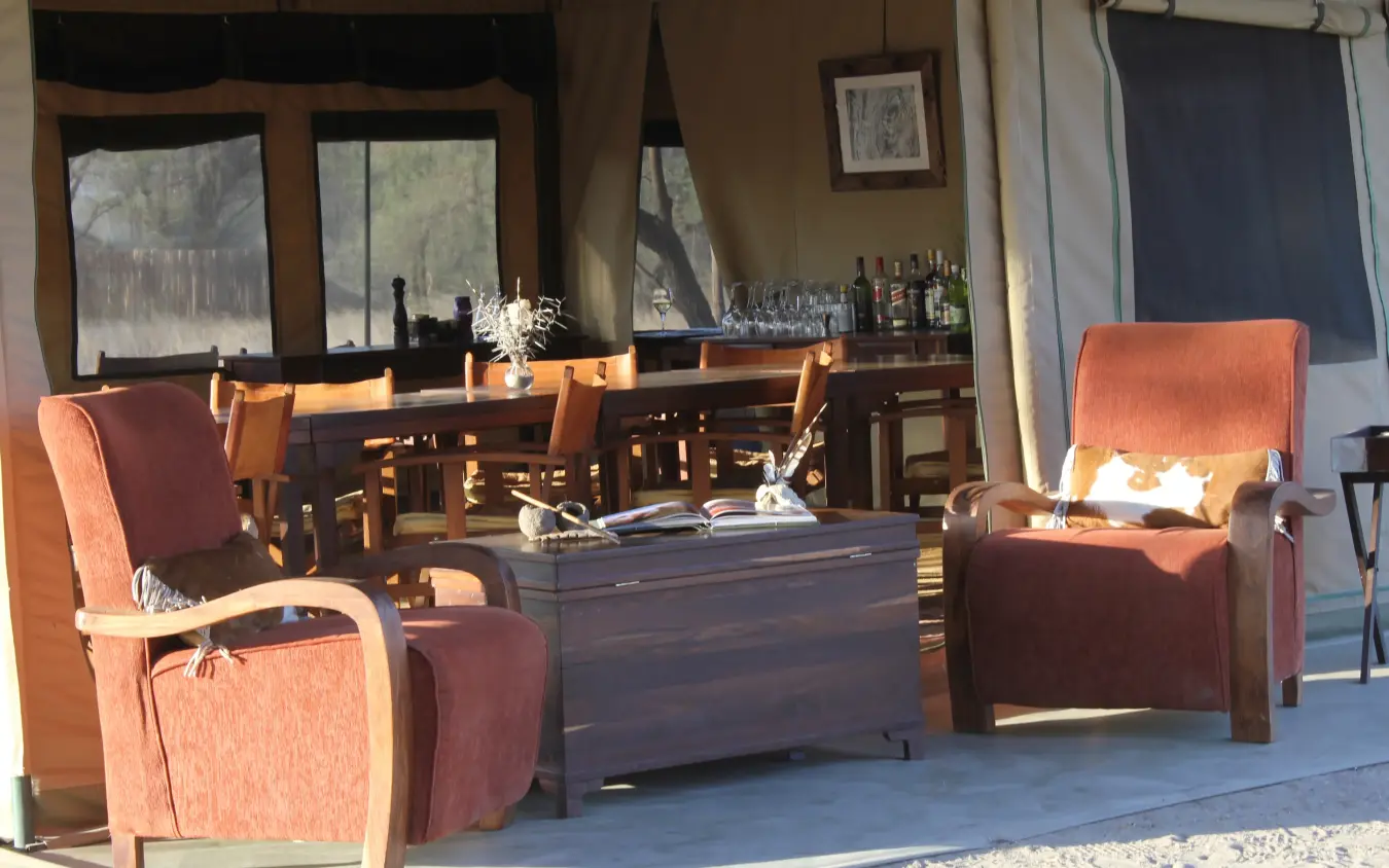 Luxury lounge area with comfortable seating and bar overlooking forest landscape, Manyara Ranch, Lake Manyara, Tanzania