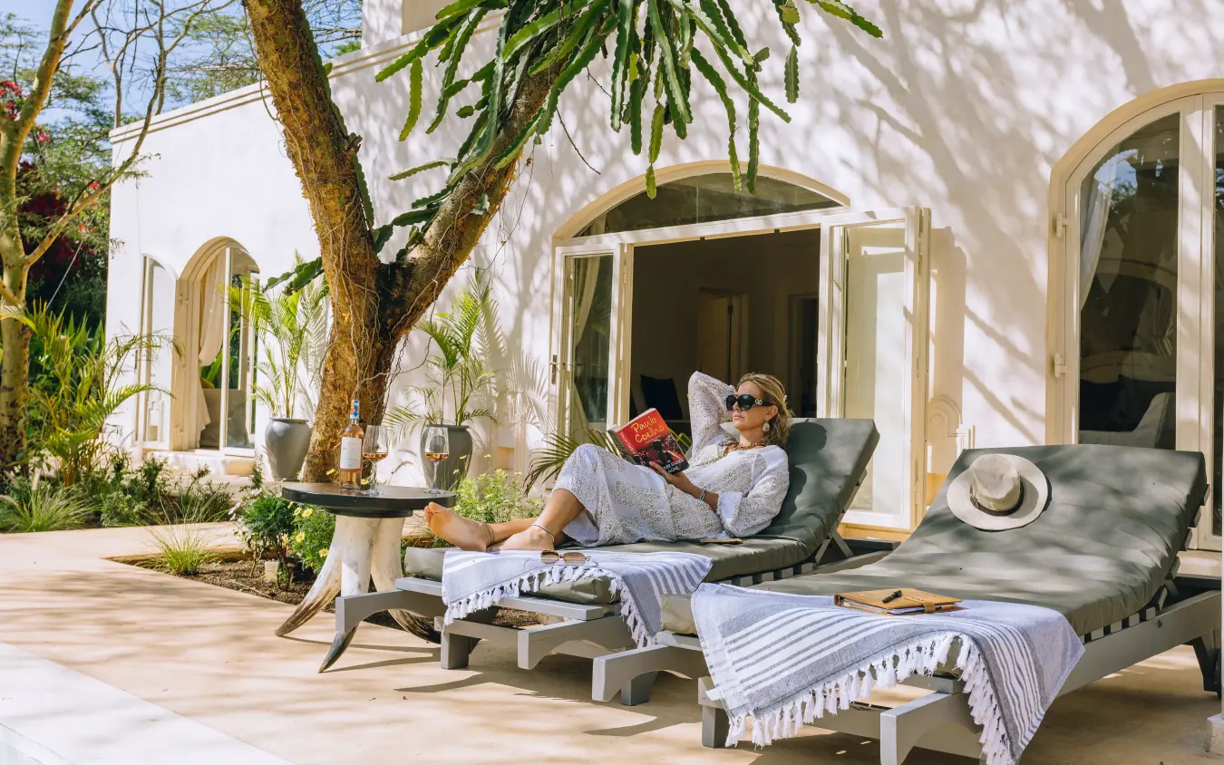 Guest relaxing on lounge chairs on sunlit terrace, Manzili House, Nairobi, Kenya