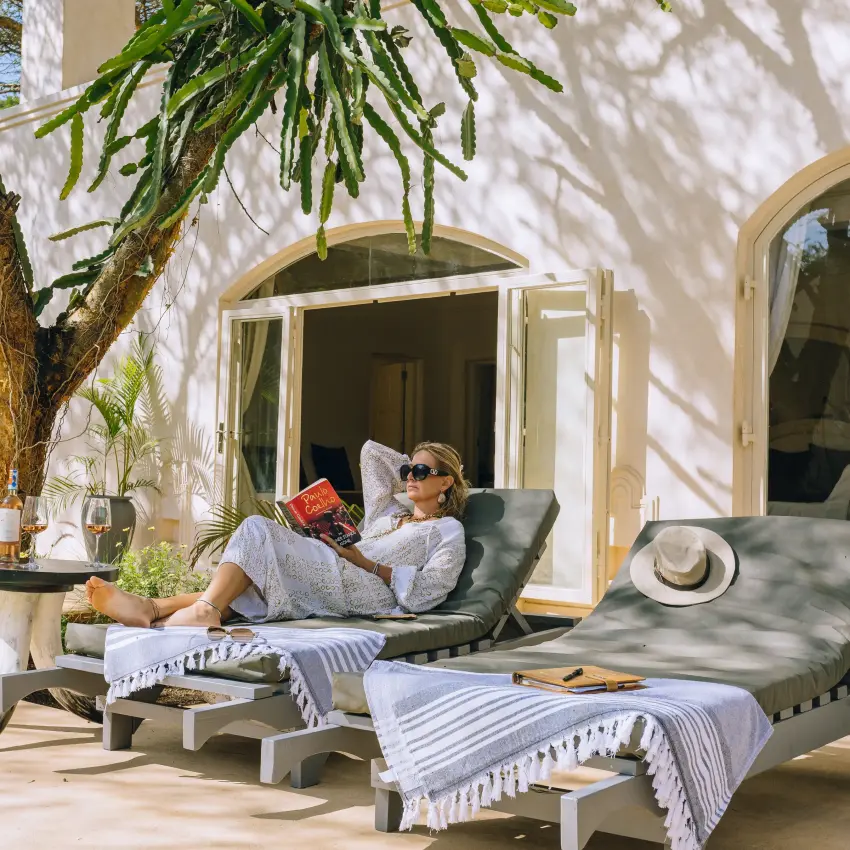 Guest relaxing on lounge chairs on sunlit terrace, Nairobi, Kenya