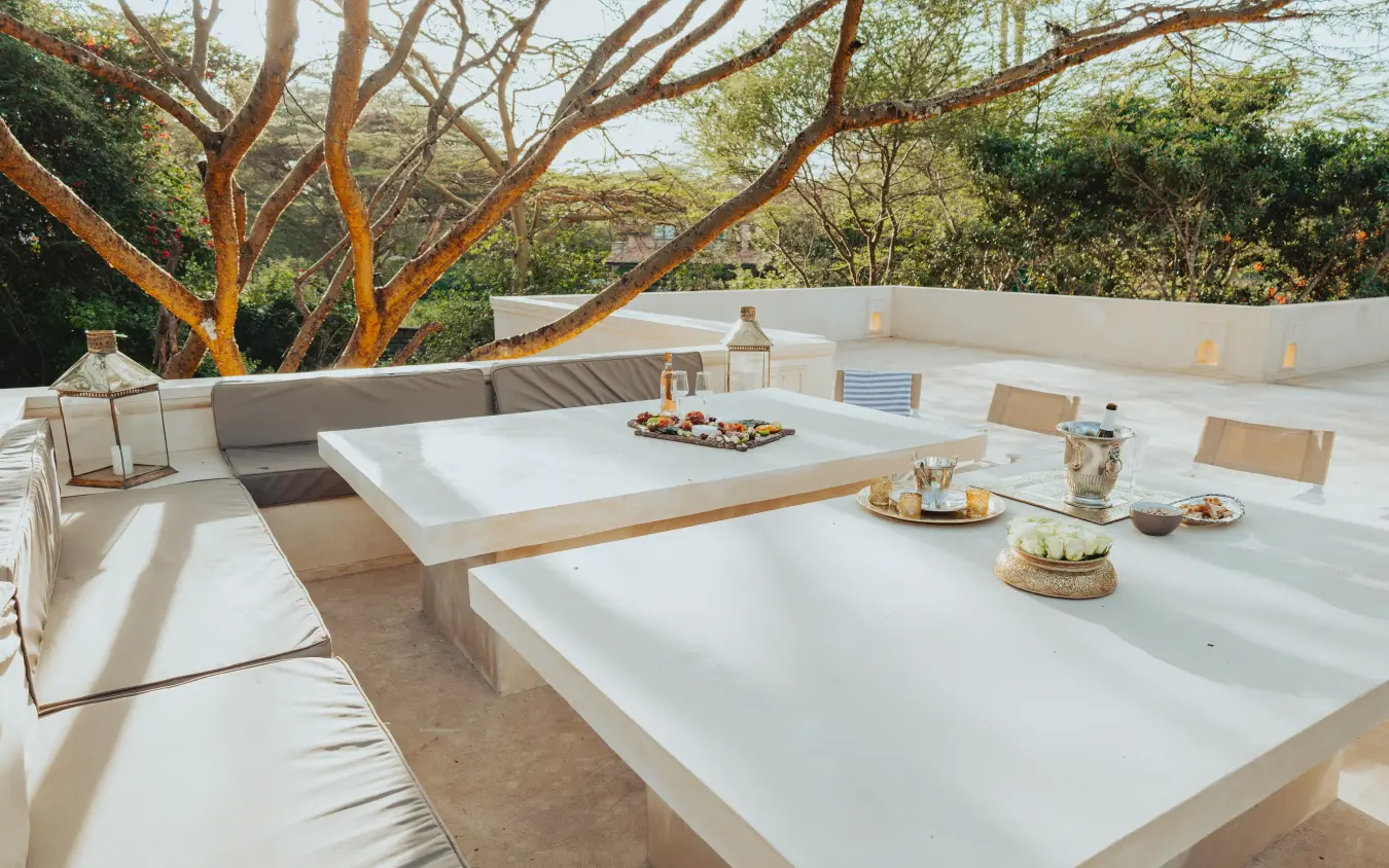 Elevated outdoor lounge area with white seating and fire pit, Manzili House, Nairobi, Kenya