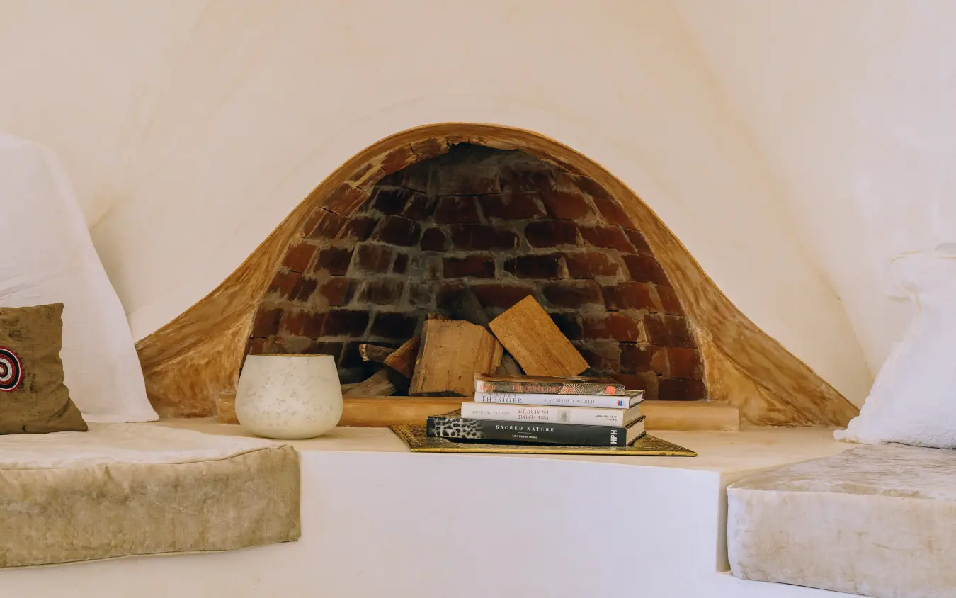 Fireplace nook with books, firewood and cushions, Manzili House, Nairobi, Kenya