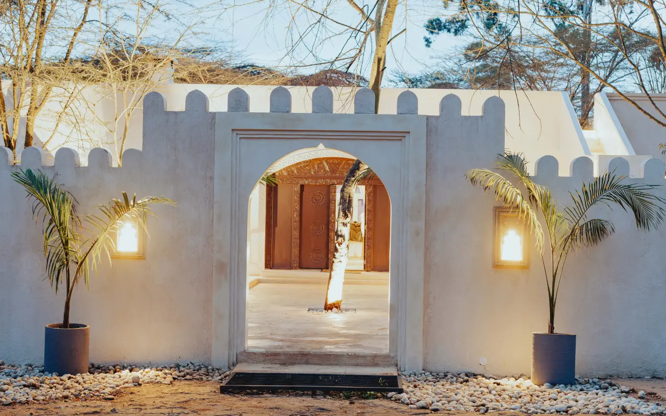 White-walled entrance gate with palm plants and lighting, Manzili House, Nairobi, Kenya