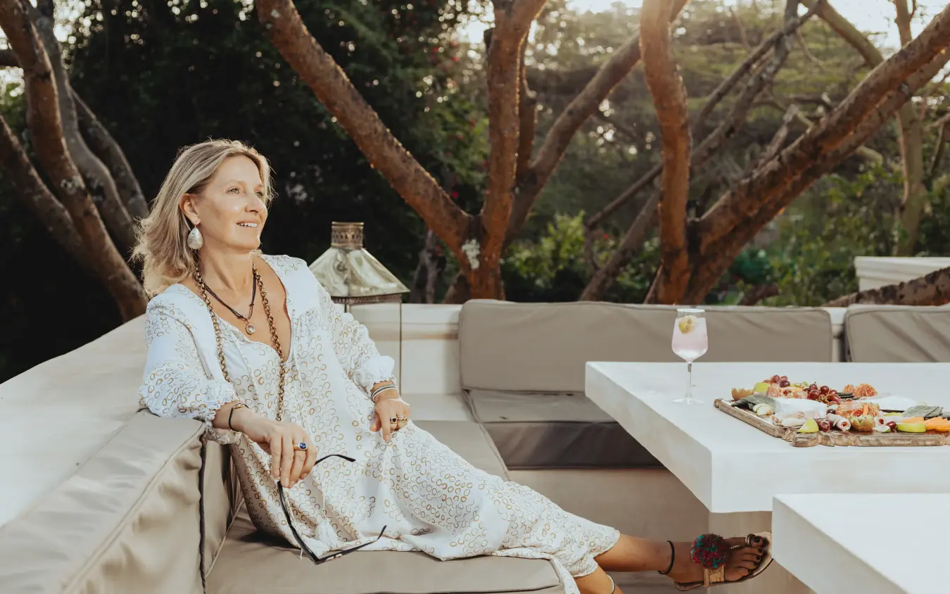 Woman relaxing on outdoor lounge seating with refreshments, Manzili House, Nairobi, Kenya