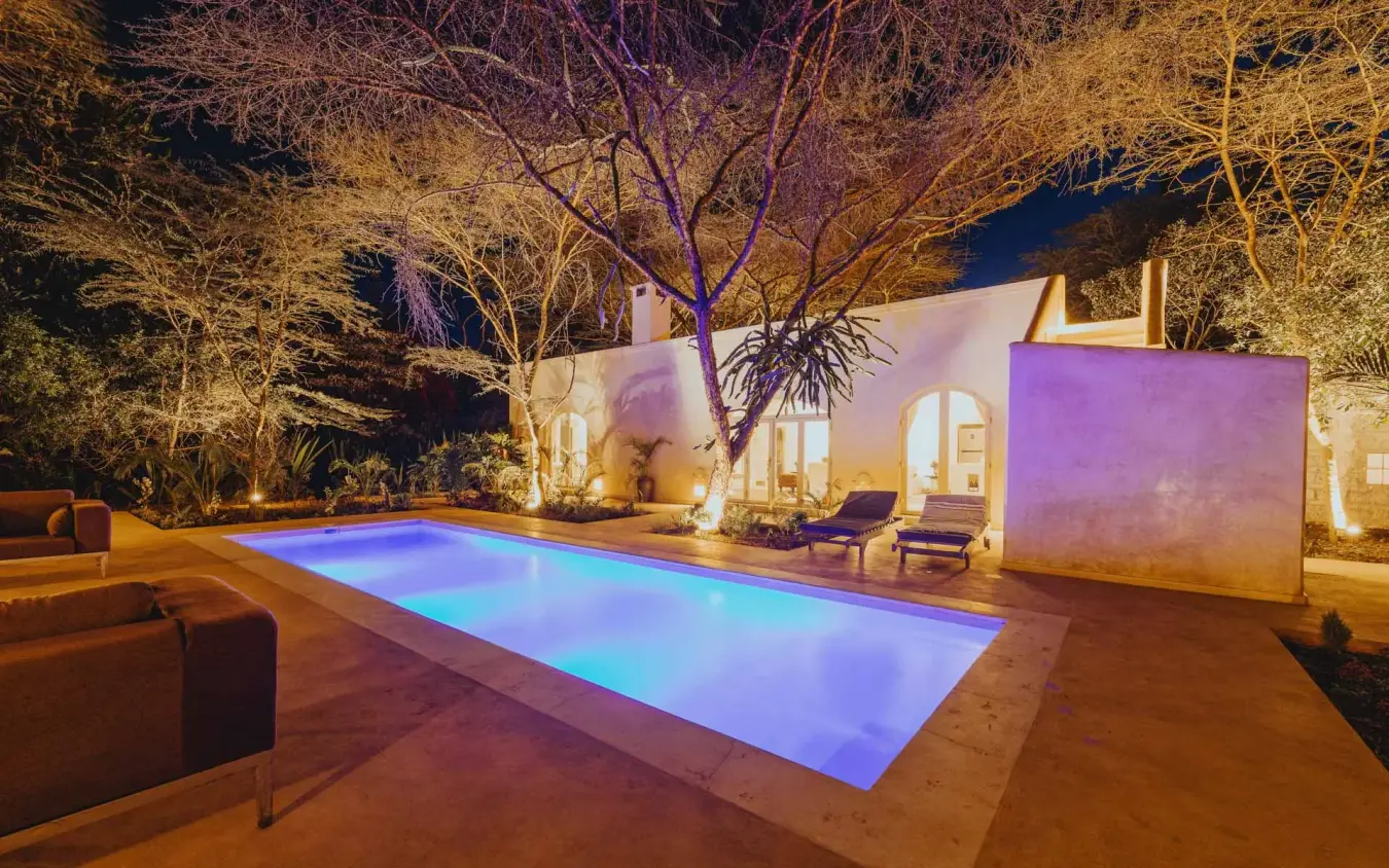 Illuminated swimming pool at night with lounge seating, Manzili House, Nairobi, Kenya