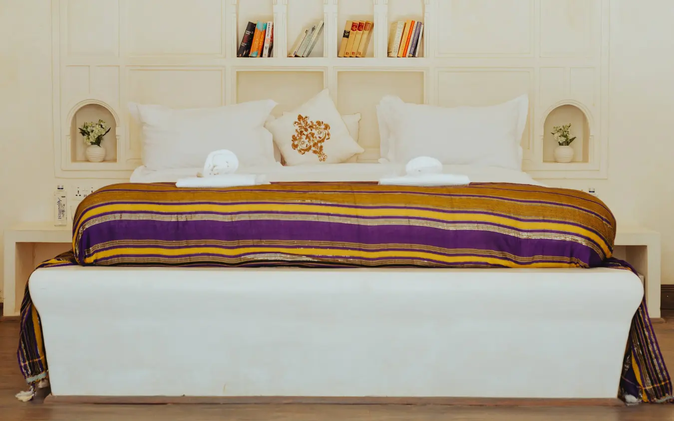 Bedroom with striped throw blanket and built-in wall shelving, Manzili House, Nairobi, Kenya