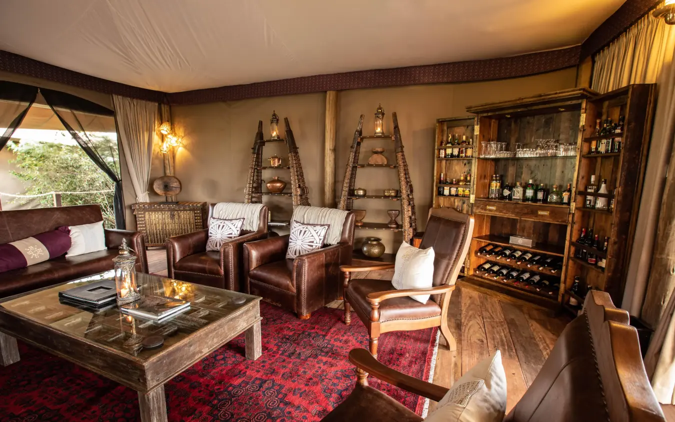 Luxury lounge with leather seating and wine cabinet display, Mara Nyika Camp, Maasai Mara, Kenya