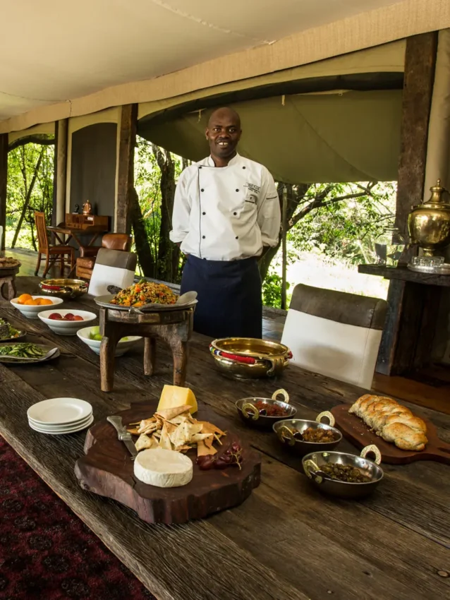 Chef presenting dishes in elegant safari lodge dining tent, Mara Plains Camp, Maasai Mara, Kenya