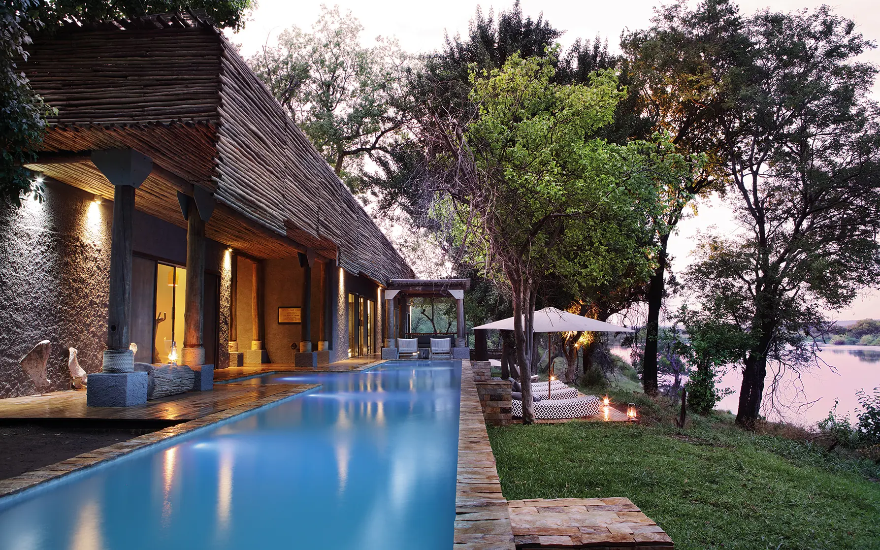 Infinity pool at dusk overlooking river and trees, Matetsi River Lodge, Victoria Falls, Zimbabwe