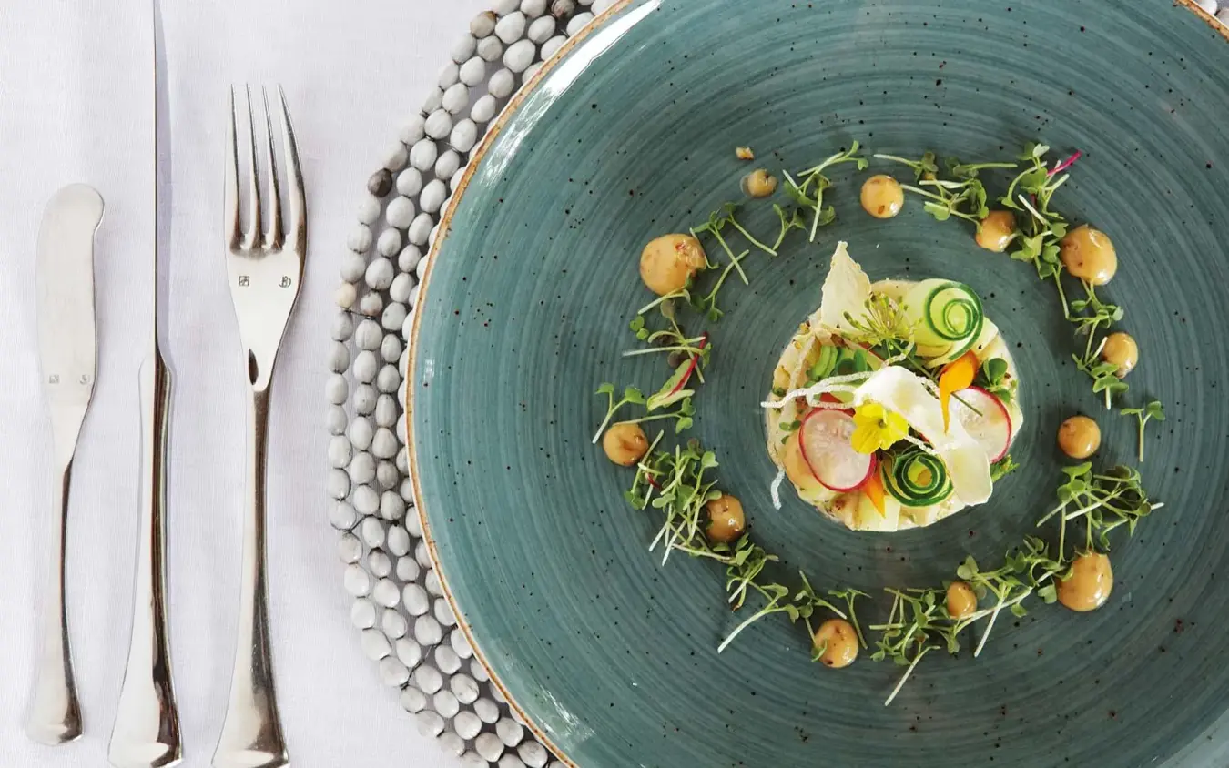 Plated dish with vegetables and microgreens on teal ceramic, Matetsi River Lodge, Victoria Falls, Zimbabwe