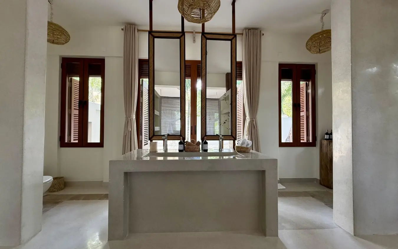 Luxurious bathroom with dual vanities and natural light from wooden shutters, Maya Kobe, Kilifi, Kenya