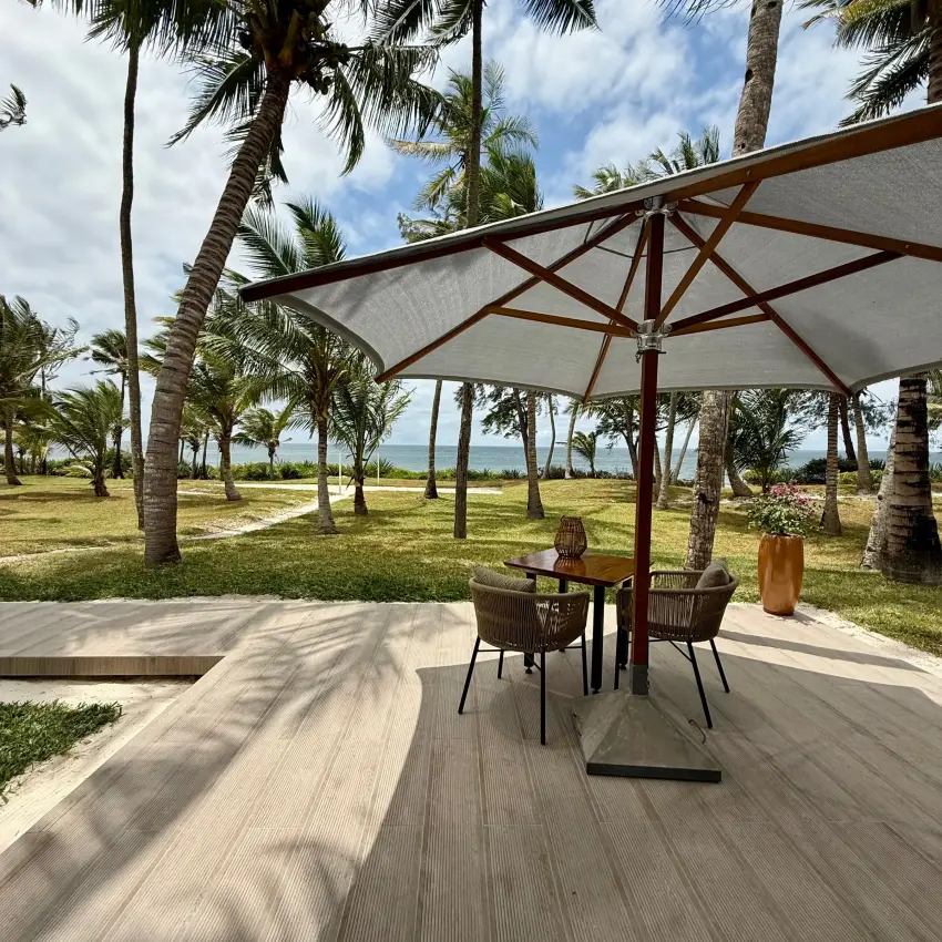Beachfront dining pavilion with ocean view through palm trees, Maya Kobe, Kilifi, Kenya
