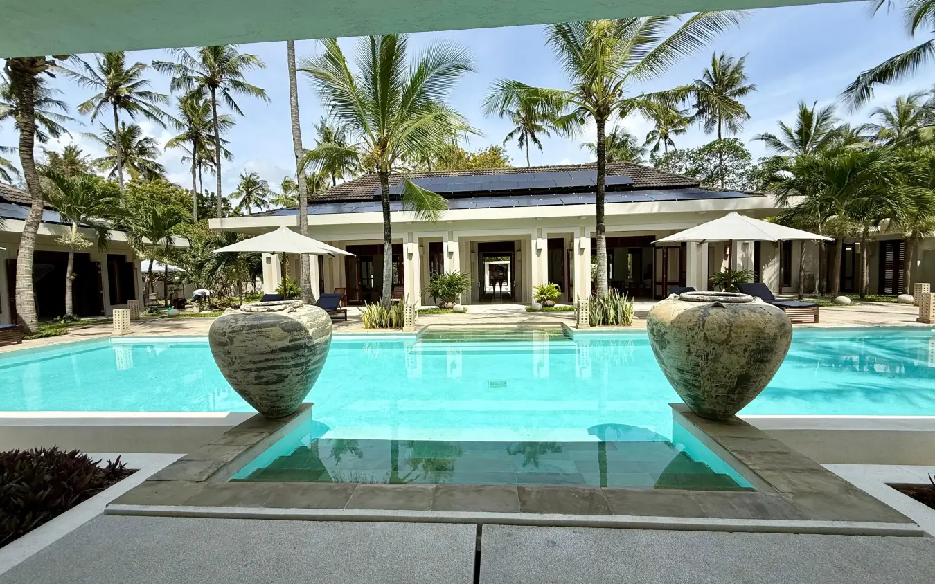 Luxury resort pool with spherical sculptures and palm trees at midday, Maya Kobe, Kilifi, Kenya
