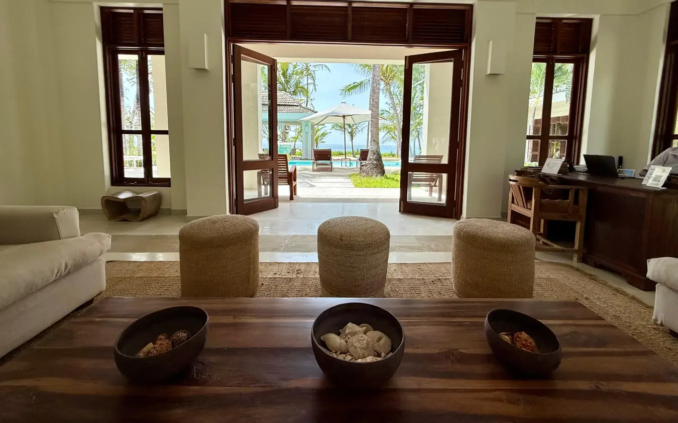 Luxury lounge with ocean view through open doors and palm trees, Maya Kobe, Kilifi, Kenya
