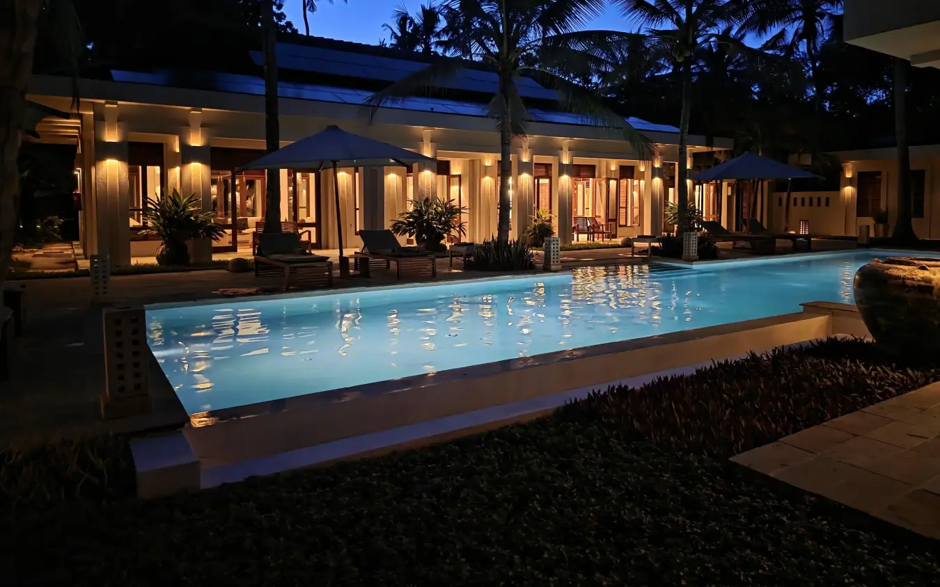 Illuminated swimming pool beside modern lodge at twilight, Maya Kobe, Kilifi, Kenya