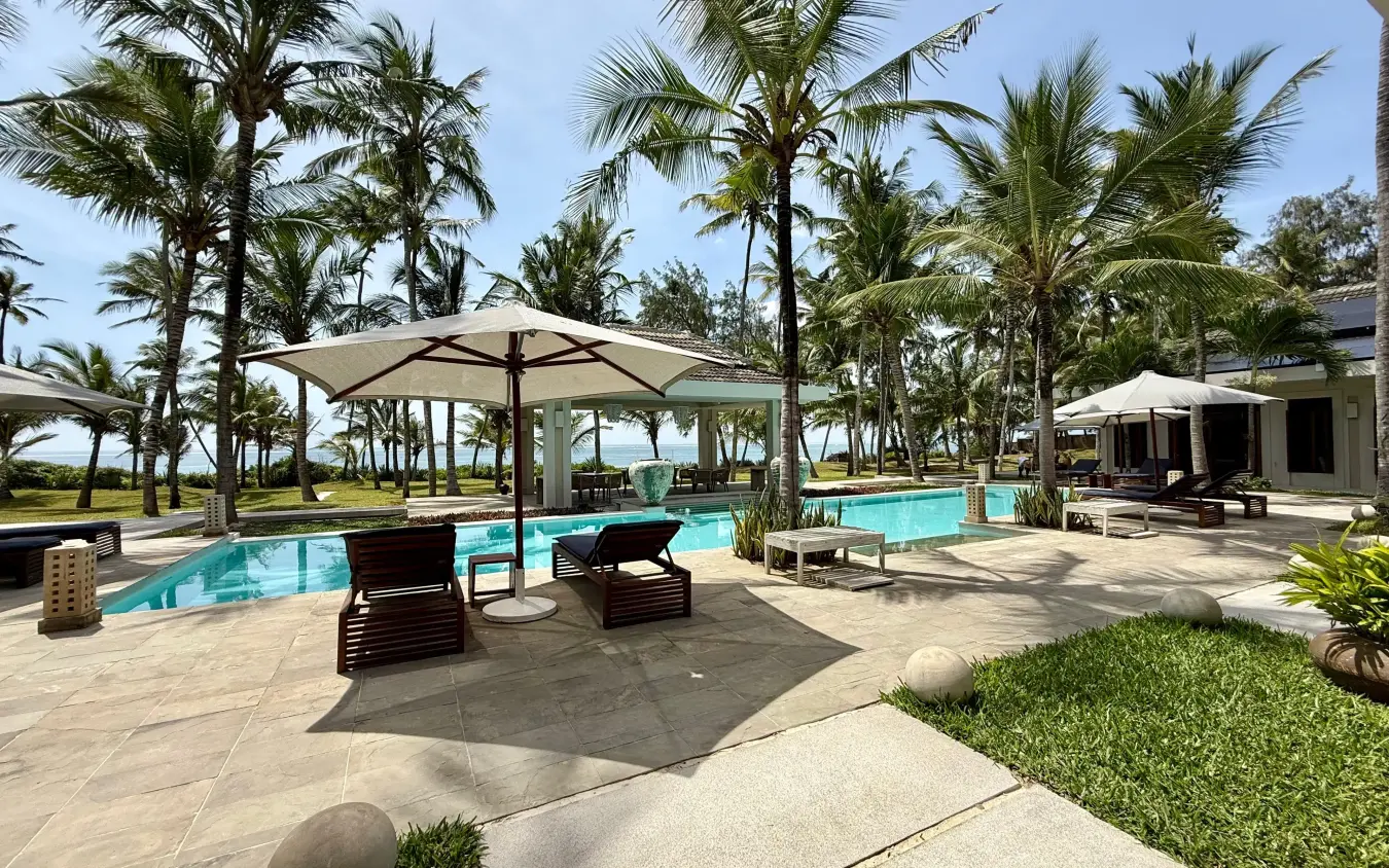 Resort pool with palm trees and loungers under umbrella shade, Maya Kobe, Kilifi, Kenya