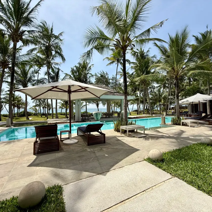 Resort pool with palm trees and loungers under umbrella shade, Maya Kobe, Kilifi, Kenya