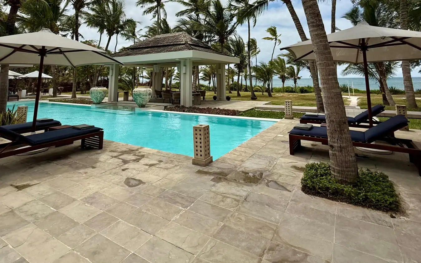 Beachfront swimming pool with loungers and palm trees overlooking ocean, Maya Kobe, Kilifi, Kenya