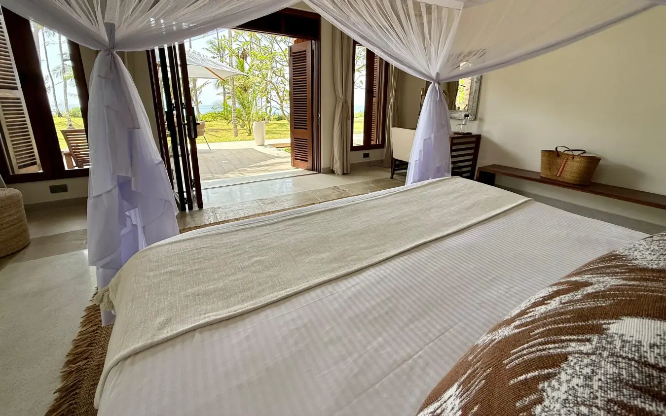 Luxury bedroom suite with canopy bed overlooking savanna landscape, Maya Kobe, Kilifi, Kenya