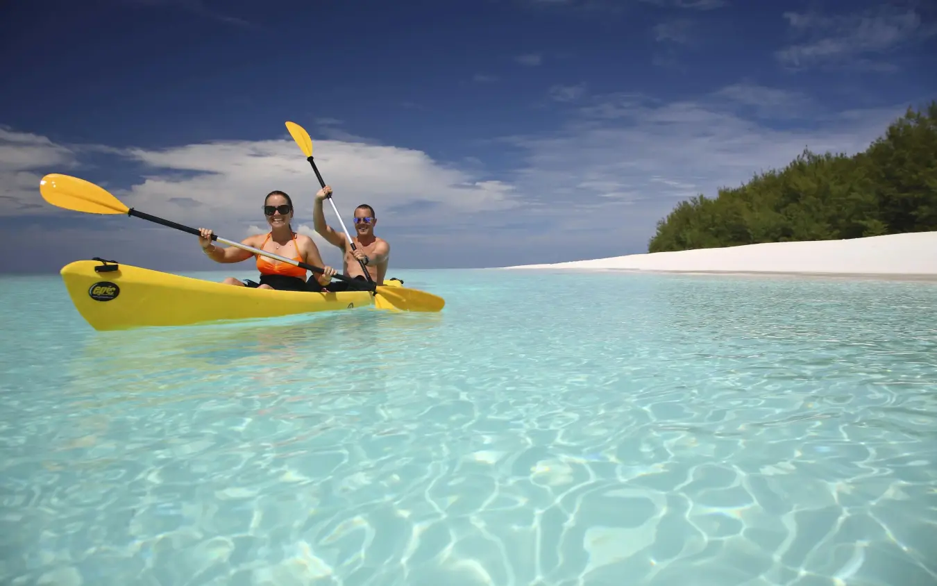 Two guests kayaking in turquoise shallow water near white sand beach, Mnemba Island, Zanzibar & Pemba, Tanzania