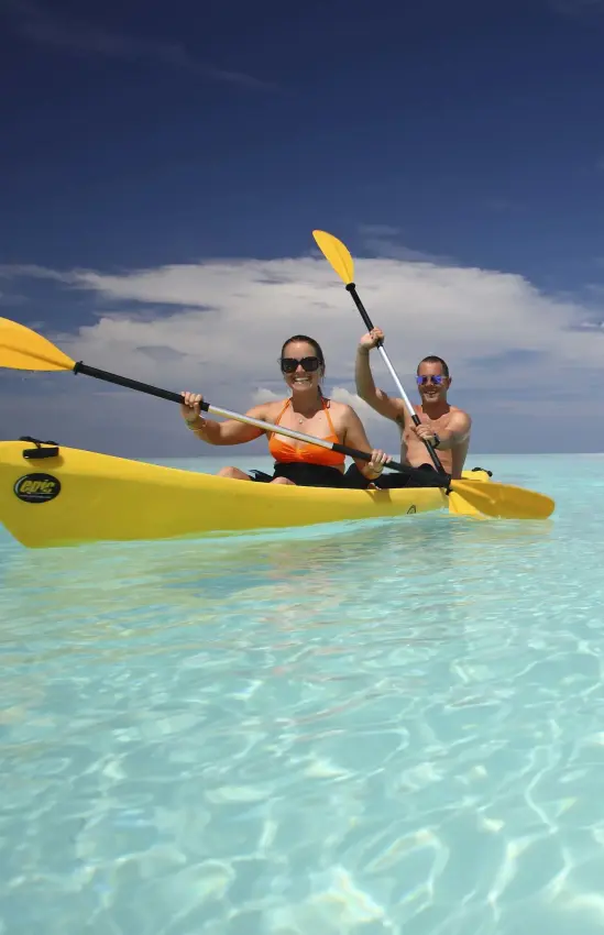 Two guests kayaking in turquoise shallow water near white sand beach, Mnemba Island, Zanzibar & Pemba, Tanzania