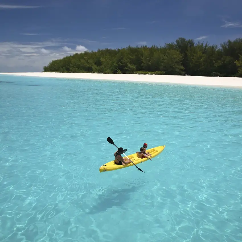 Guest kayaking in turquoise waters near white sand beach, Mnemba Island, Zanzibar & Pemba, Tanzania