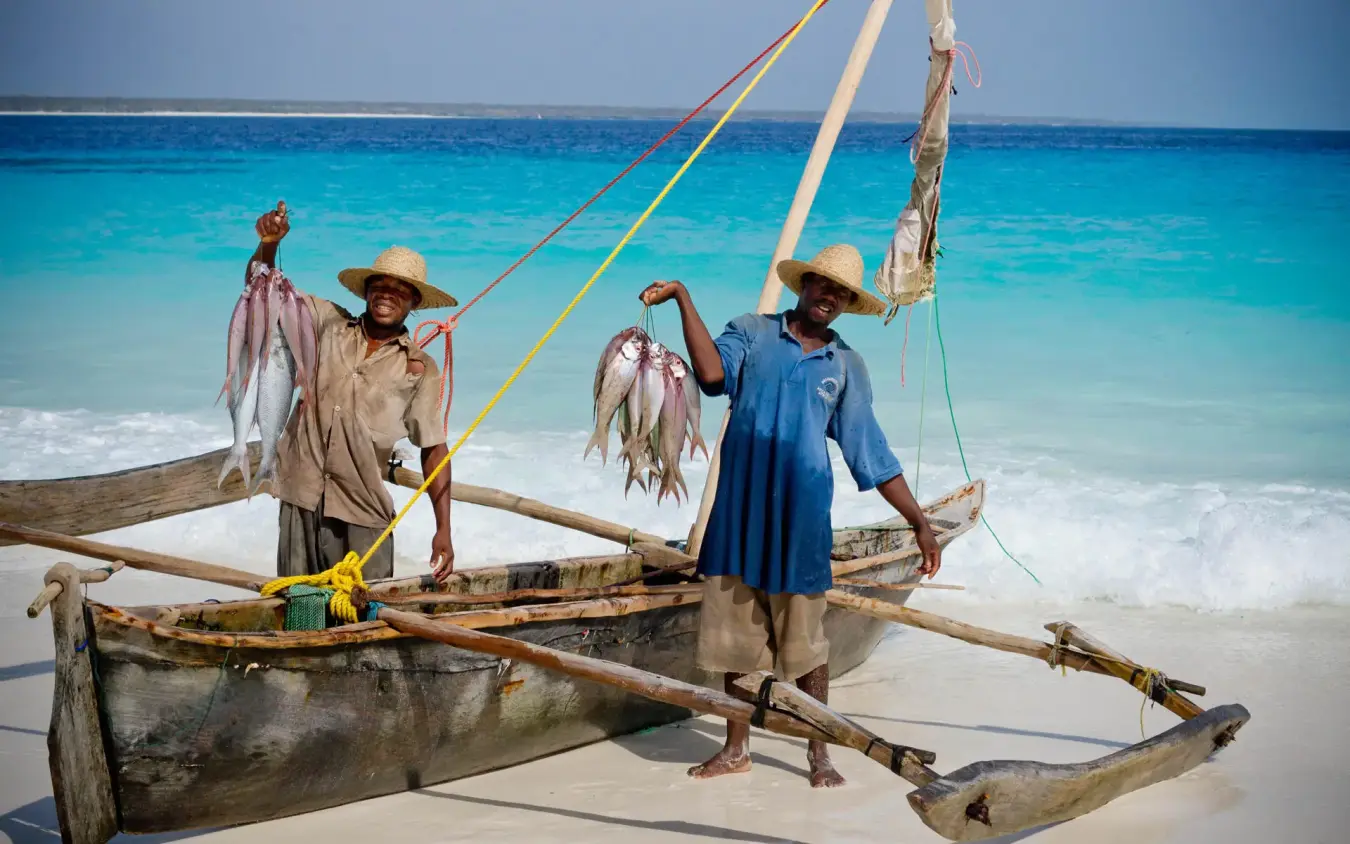 Fishermen displaying daily catch from traditional sailing boat, Mnemba Island, Zanzibar & Pemba, Tanzania