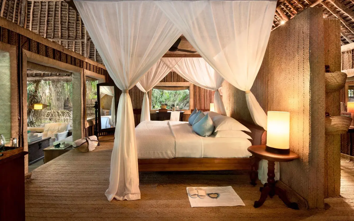 Spacious bedroom with four-poster bed and flowing white curtains, Mnemba Island, Zanzibar & Pemba, Tanzania