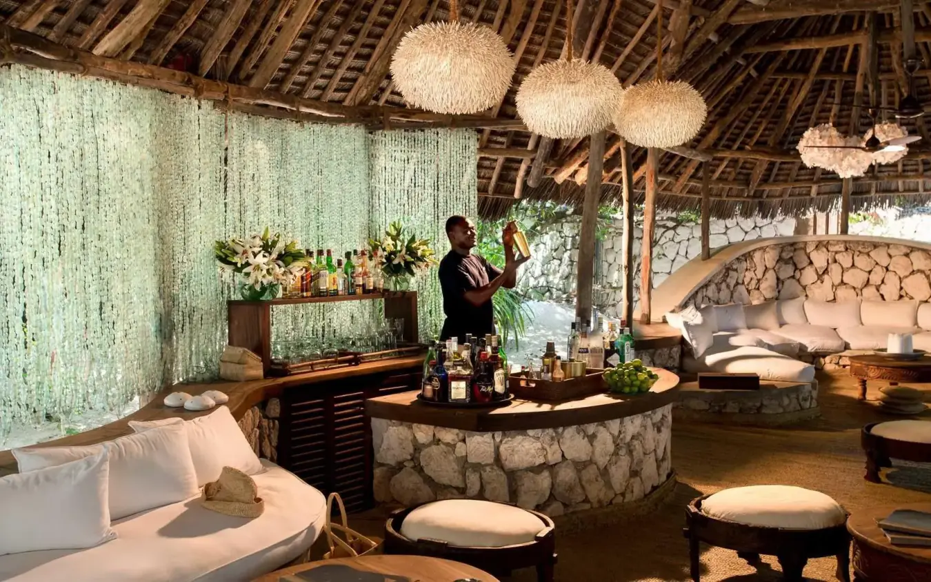 Thatched lounge with stone bar and seating areas, Mnemba Island, Zanzibar & Pemba, Tanzania