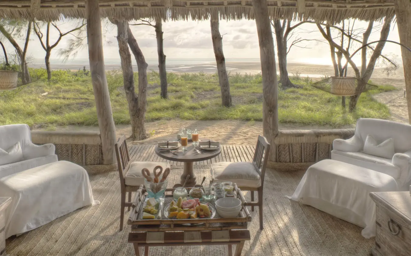 Open-air lounge pavilion with white furniture overlooking coastal landscape, Mnemba Island, Zanzibar & Pemba, Tanzania