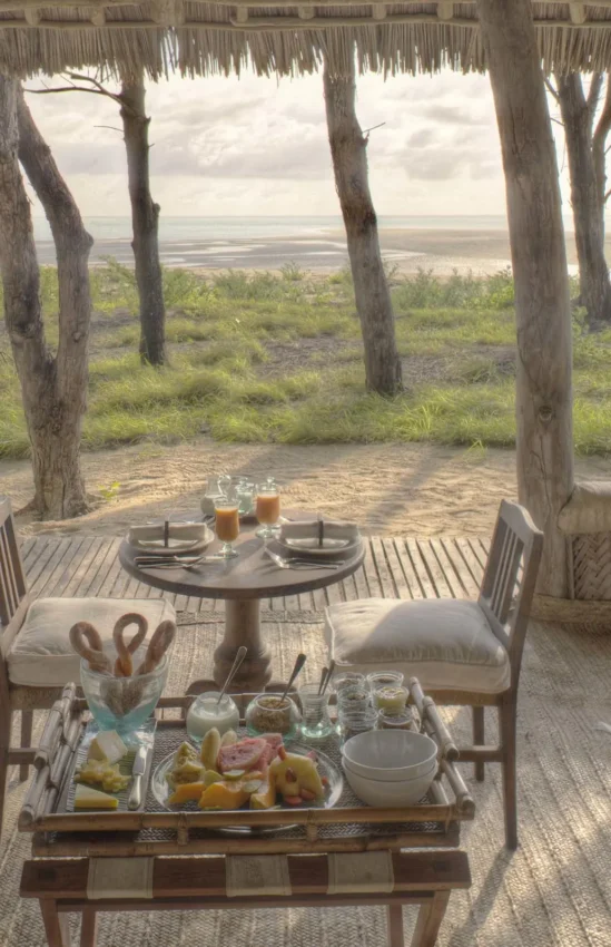 Open-air lounge pavilion with white furniture overlooking coastal landscape, Mnemba Island, Zanzibar & Pemba, Tanzania