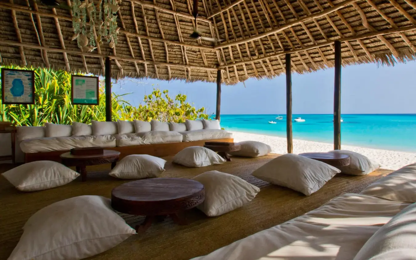 Beach lounge with cushioned seating overlooking turquoise ocean, Mnemba Island, Zanzibar & Pemba, Tanzania