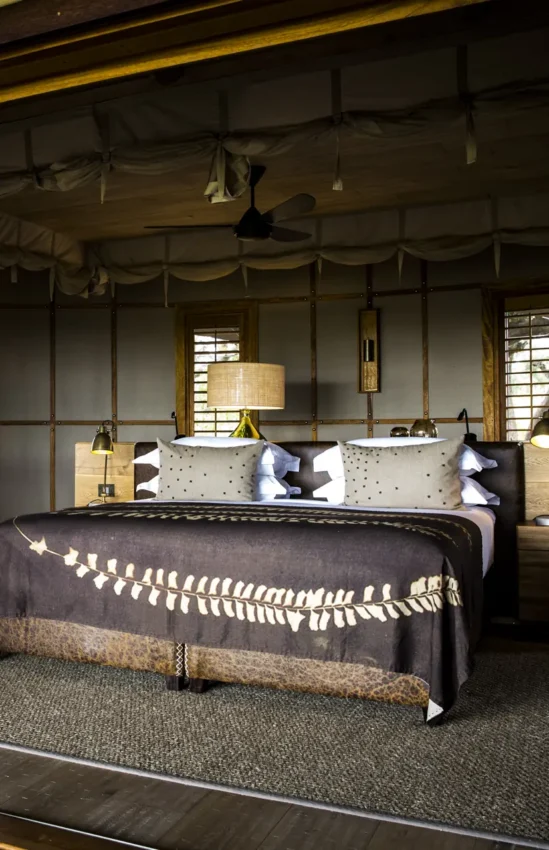 Luxury bedroom with decorative fabric panels and pendant lighting, Mombo Camp, The Okavango Delta, Botswana