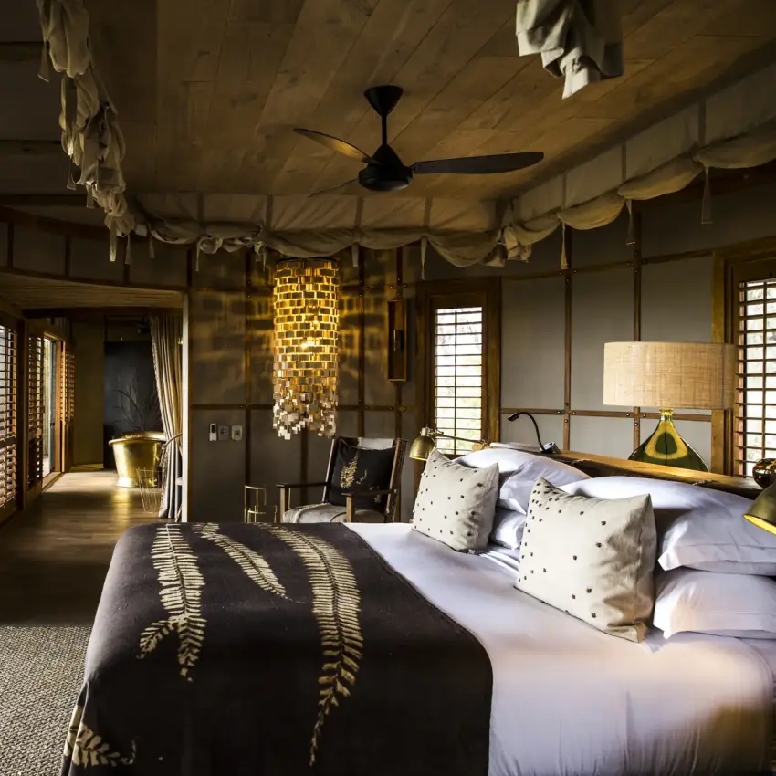 Luxury bedroom suite with open terrace overlooking natural landscape, Mombo Camp, The Okavango Delta, Botswana