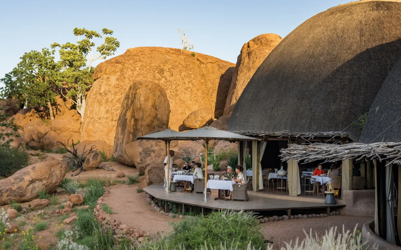 Luxury dining pavilion nestled among giant boulders at sunset, Mowani Mountain Camp, Damaraland, Namibia