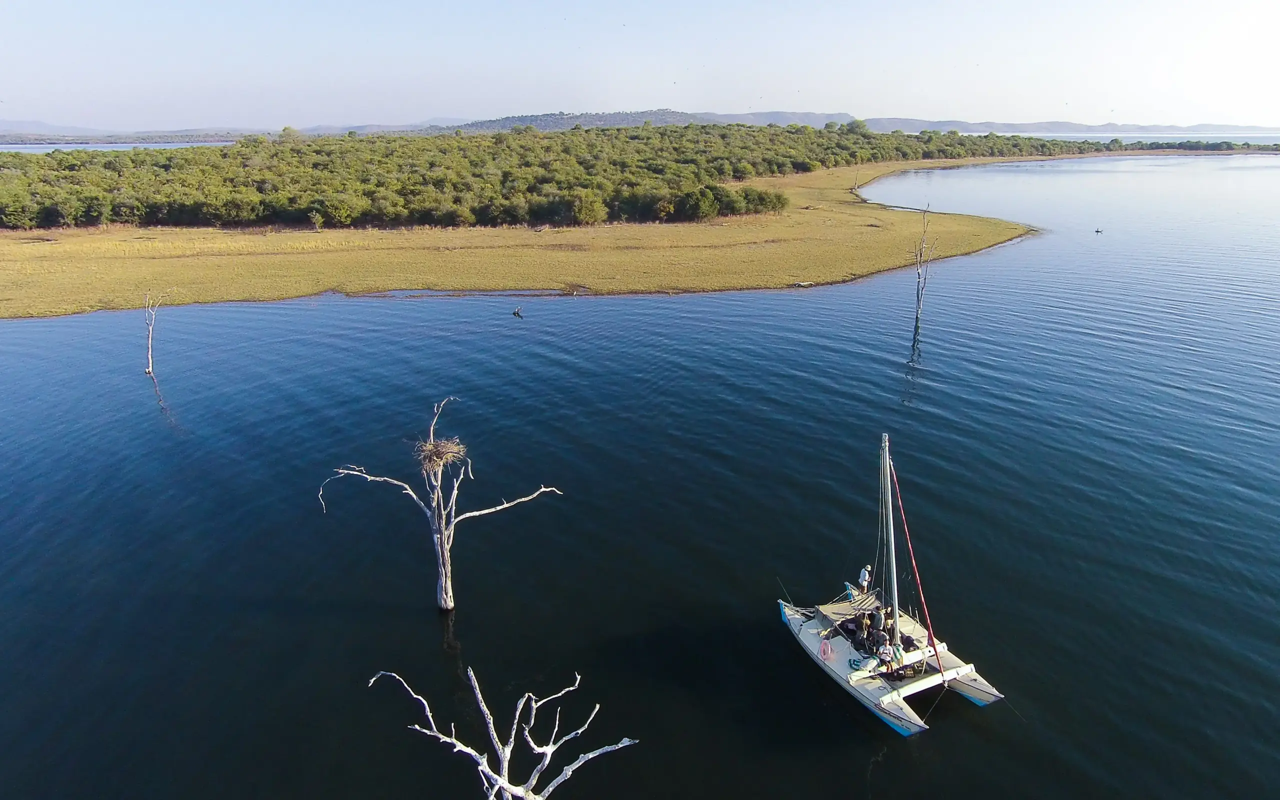 Sailboat anchored in calm blue water near mangroves, Zimbabwe