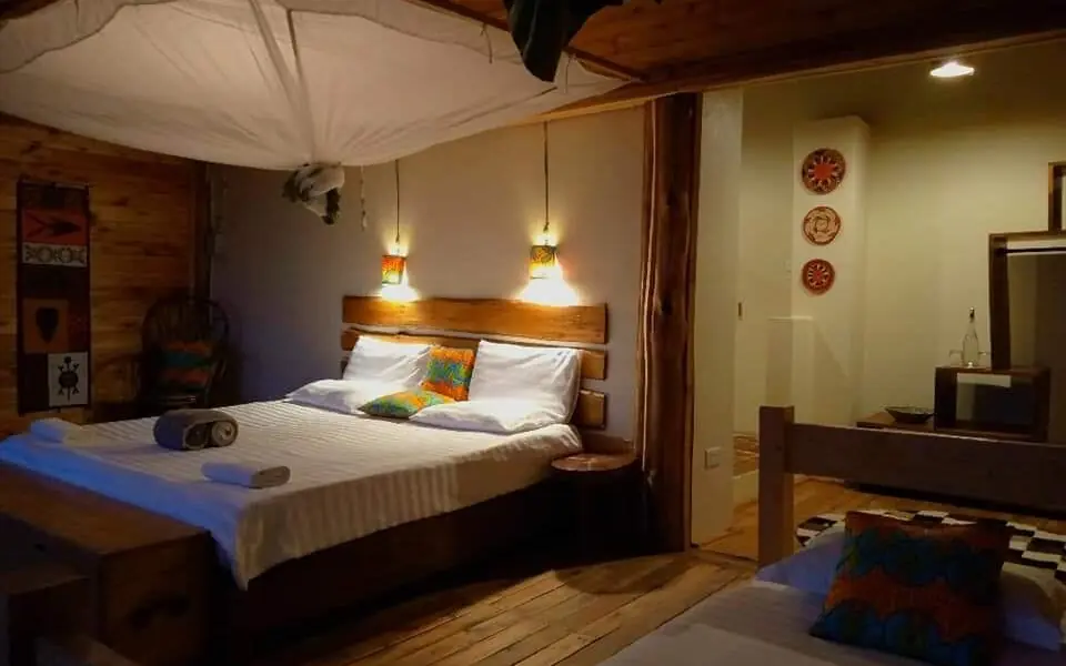 Wooden bedroom with canopy bed and pendant lighting, Mutanda Lake Resort, Lake Mutanda, Uganda