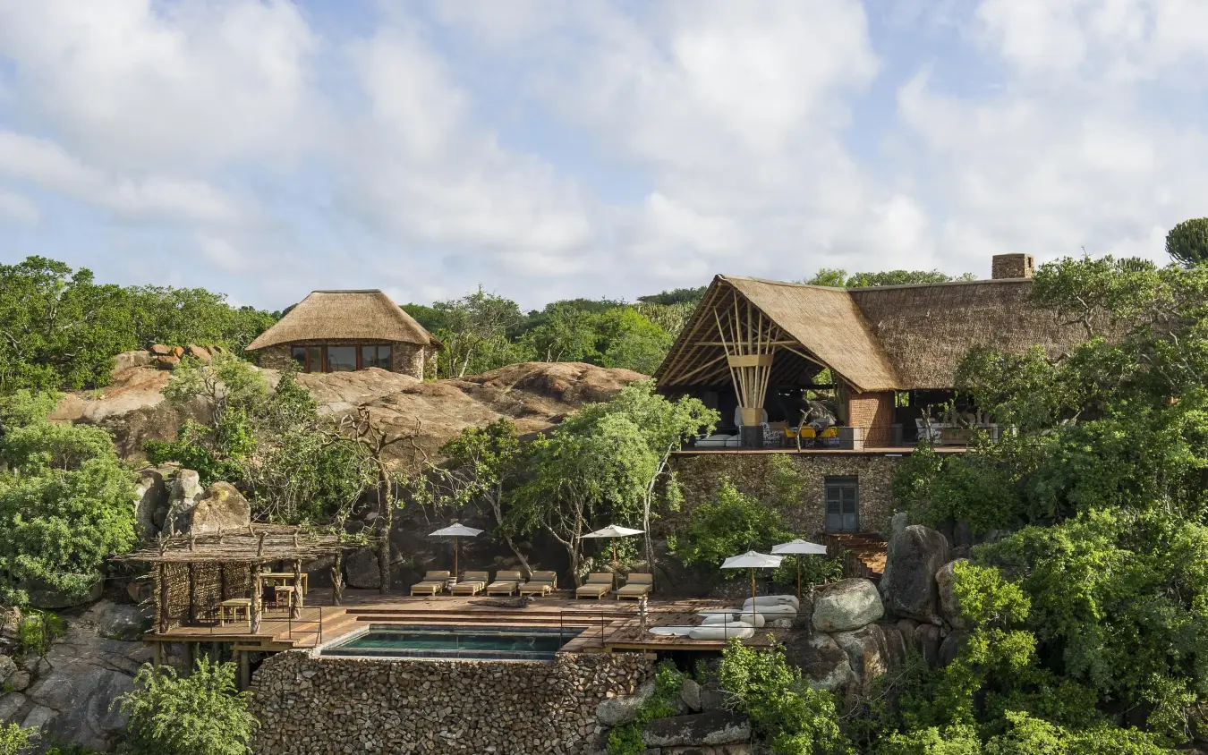 Safari lodge buildings with thatched roofs nestled among trees, Mwiba Lodge, Serengeti National Park, Tanzania