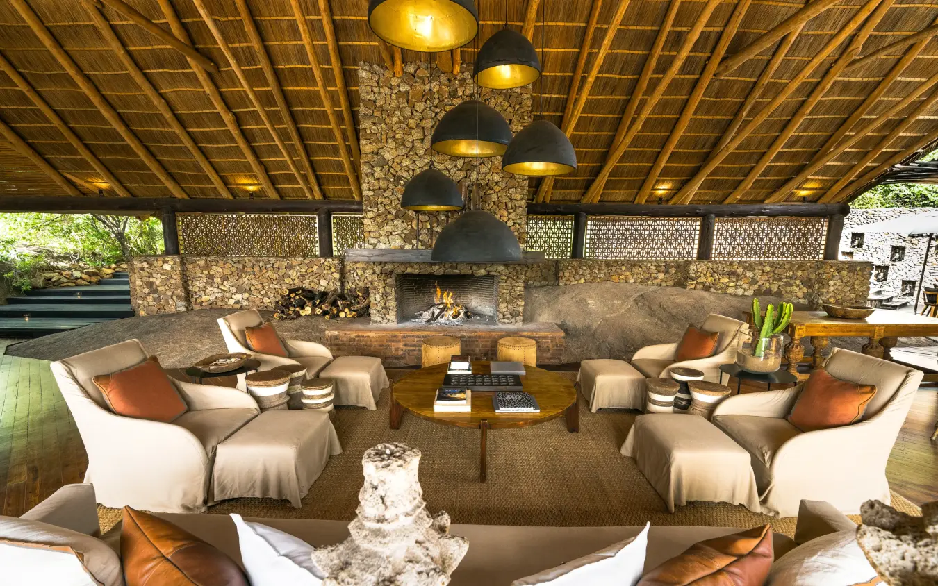 Covered lounge area with fireplace and comfortable seating, Mwiba Lodge, Serengeti National Park, Tanzania