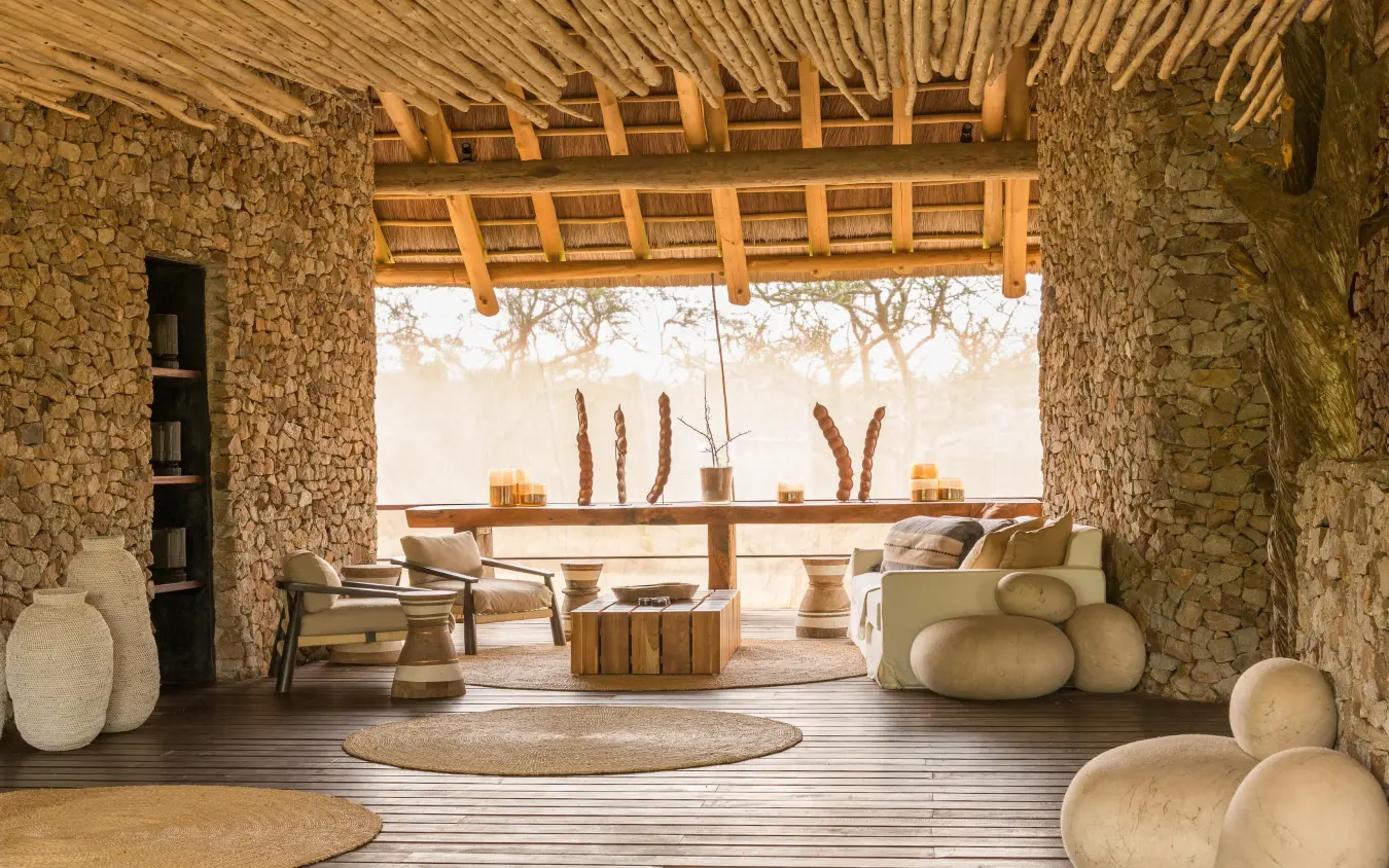 Open-air lounge pavilion with stone walls and wooden furniture, Mwiba Lodge, Serengeti National Park, Tanzania