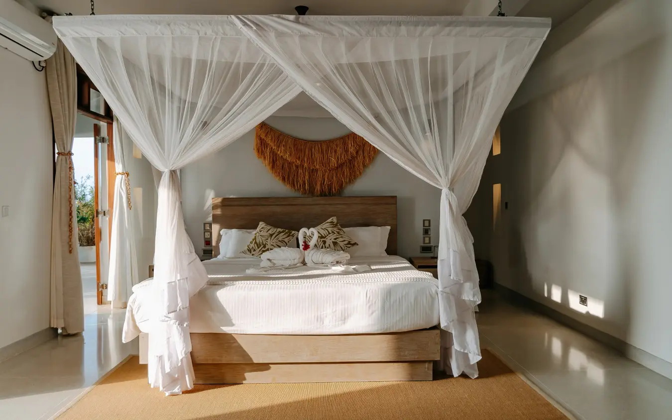 Canopy bed with white drapes in modern bedroom suite, My Amani, Kilifi, Kenya