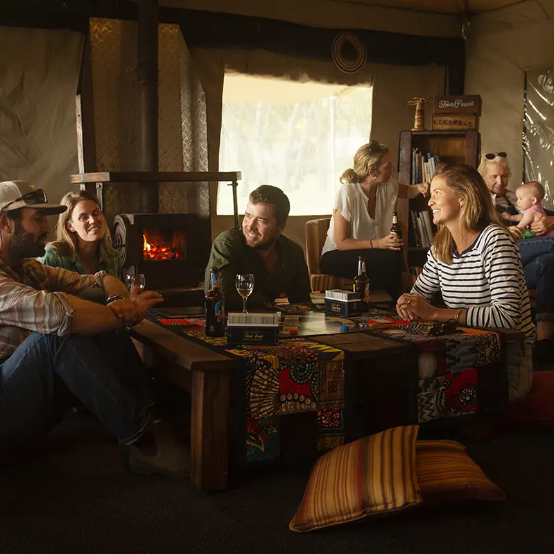 Guests gathered in lodge lounge around fireplace, Mysigio Camp, Ngorongoro Crater, Tanzania