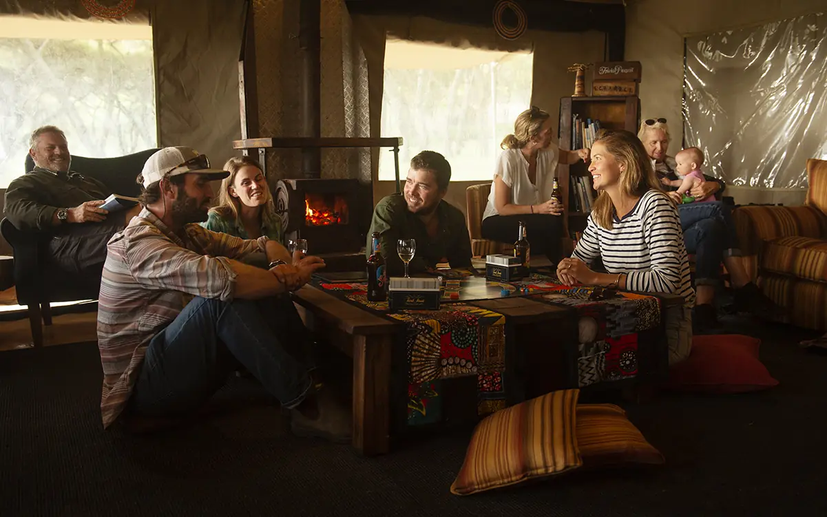 Guests gathered in lodge lounge around fireplace, Mysigio Camp, Ngorongoro Crater, Tanzania