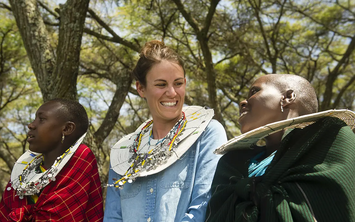 Woman with local guides wearing traditional beaded jewelry, Mysigio Camp, Ngorongoro Crater, Tanzania